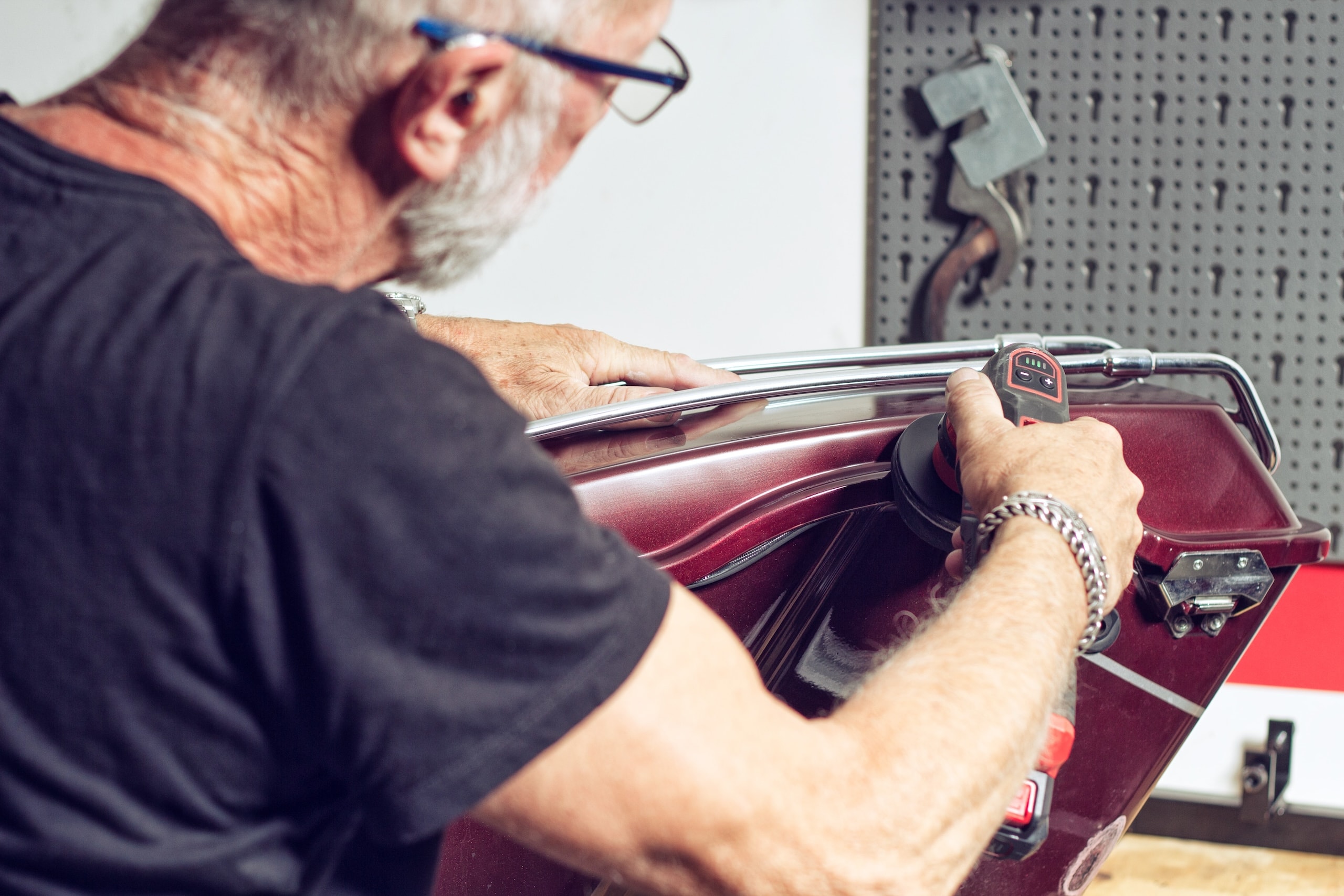 Ein Mechaniker der an einem Karosserieteil arbeitet