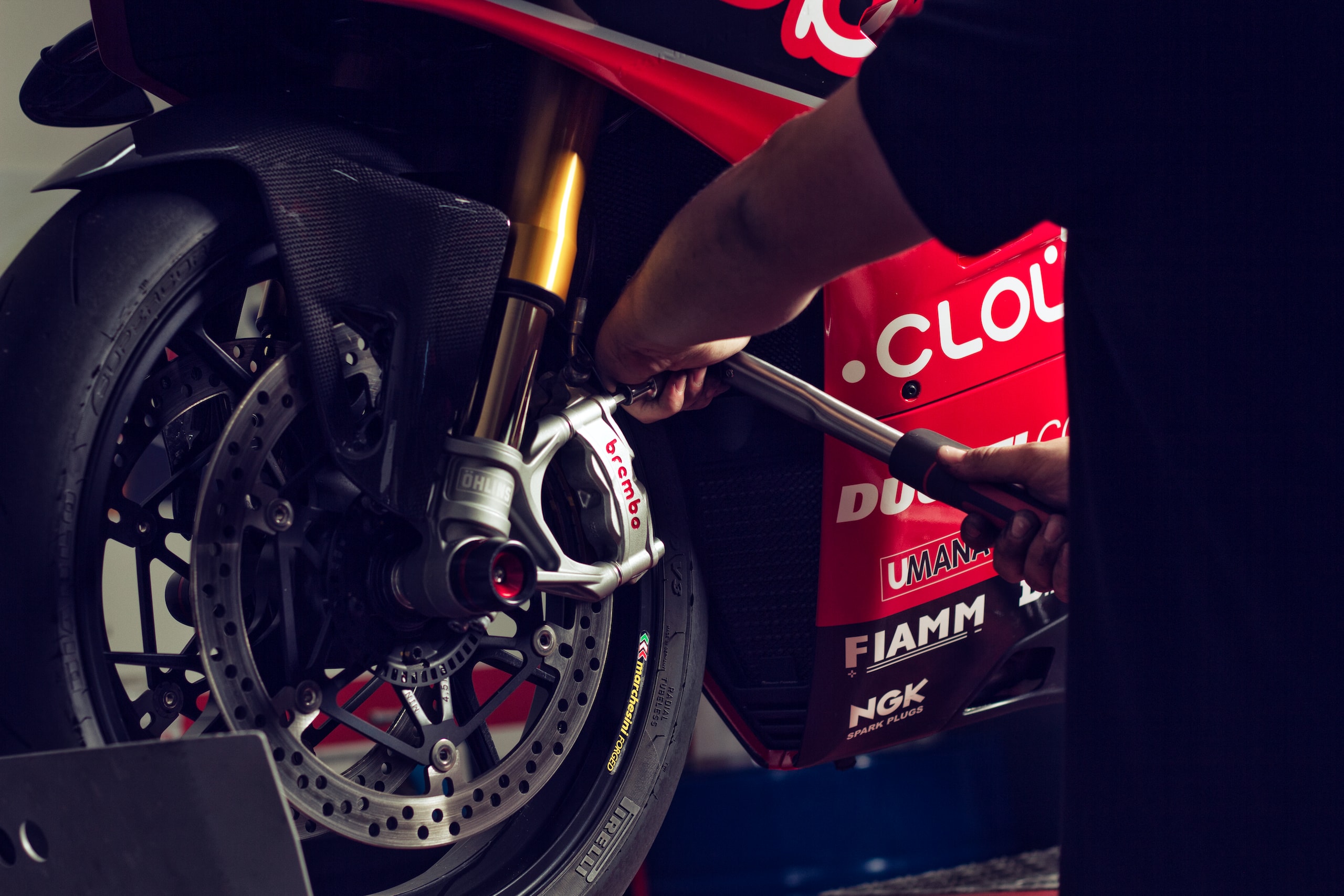 Ein Mechaniker der an einem roten Rennsport Motorrad arbeitet